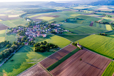 Agricultural land and field borders surround the settlement area of the village in Dingolshausen in the state Bavaria, Germany