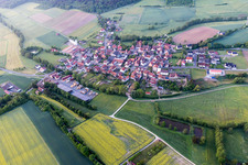 Aerial view of Agricultural land and field borders surround the settlement area of the village in Wustviel in the state Bavaria, Germany
