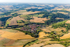 Aerial view of Agricultural land and field borders surround the settlement area of the village in Niedermoschel in the state Rhineland-Palatinate, Germany