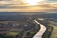 Two paragliders at sunrise over the Main in the district Untertheres in Theres in the state Bavaria, Germany
