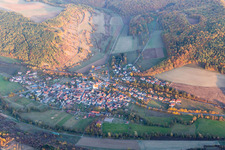 Agricultural land and field borders surround the settlement area of the village in Binsfeld in the state Bavaria, Germany from above