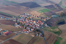 Aerial view of Agricultural land and field borders surround the settlement area of the village in Frankenwinheim in the state Bavaria, Germany