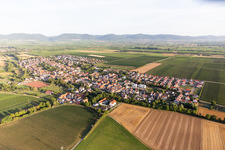 Agricultural land and field borders surround the settlement area of the village in Essingen in the state Rhineland-Palatinate, Germany seen from above