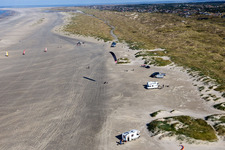 Buggies and kite surfers on the sandy beach in Fanø in the state South Denmark, Denmark from above