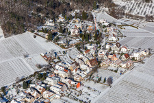 Aerial view of Wintry snowy village on the edge of vineyards and wineries in the wine-growing area in Weyher in der Pfalz in the state Rhineland-Palatinate, Germany