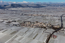 Aerial photograpy of Wintry snowy village - view on the edge of agricultural fields and farmland in Walsheim in the state Rhineland-Palatinate, Germany