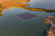 Oblique view of Floating solar power plant and panels of photovoltaic systems on the surface of the water on a quarry pond for gravel extraction in Leimersheim in the state Rhineland-Palatinate, Germany