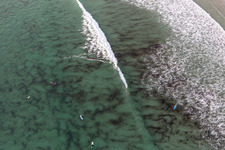 Aerial view of Wave surfers in front of Plage la Torche-Tronoën in Plomeur in the state Finistere, France