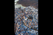 Main street with parish church of St. Michael in winter with snow in Rheinzabern in the state Rhineland-Palatinate, Germany from the plane