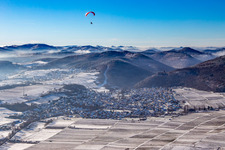 Aerial view of From the east in winter in the snow with paraglider in Klingenmünster in the state Rhineland-Palatinate, Germany