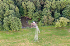 High-voltage pylon at the edge of the forest with fishing pond in the district Burkersdorf in Zittau in the state Saxony, Germany