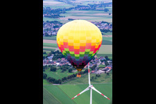 Hot air balloon flies close to the wind turbine in the district Straeten in Heinsberg in the state North Rhine-Westphalia, Germany
