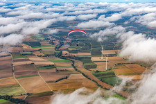 Paraglider over the wind farm Freckenfeld in clouds in Freckenfeld in the state Rhineland-Palatinate, Germany
