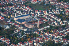 School building of the Ernst-Reuter school and Tower and building of St. Ulrich church in Hassloch in the state Rhineland-Palatinate