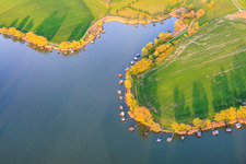 Boardwalks with fishing huts line the shore of Lake Etang du Welschhof. in Puttelange-aux-Lacs in the state Moselle, France