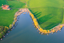 Boardwalks with fishing huts line the shore of Lake Etang du Welschhof. in Puttelange-aux-Lacs in the state Moselle, France