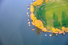 Boardwalks with fishing huts line the shore of Lake Etang du Welschhof. in Puttelange-aux-Lacs in the state Moselle, France