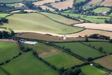 Historic windmill on a farm homestead on the edge of cultivated fields in North Whilborough in England, United Kingdom