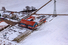 Oblique view of Village market Schoßberghof In winter with snow in Minfeld in the state Rhineland-Palatinate, Germany