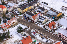 Main street in winter in the snow in Hergersweiler in the state Rhineland-Palatinate, Germany from above