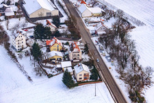 Drone recording of Main street in winter in the snow in Hergersweiler in the state Rhineland-Palatinate, Germany