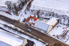 Main street in winter in the snow in Hergersweiler in the state Rhineland-Palatinate, Germany from the drone perspective