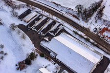 Main street in winter in the snow in Hergersweiler in the state Rhineland-Palatinate, Germany from a drone