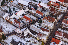 Aerial view of Raiffeisenstraße x Hauptstraße in snow in Winden in the state Rhineland-Palatinate, Germany