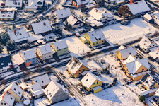 Oblique view of Raiffeisenstraße in winter with snow in Rheinzabern in the state Rhineland-Palatinate, Germany