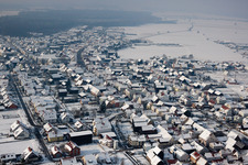 Wintry snowy Village - view on the edge of agricultural fields and farmland in Hatzenbuehl in the state Rhineland-Palatinate, Germany