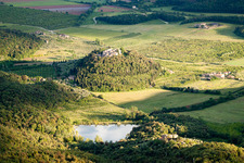 Village - view on a wooded, round hill with lake in the district Poggio Santa Cecilia in Rapolano Terme in the state Siena, Italy