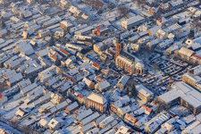 Oblique view of Christmas market at Plätzl and around St. George's Church in snow in Kandel in the state Rhineland-Palatinate, Germany