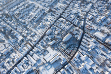 Aerial view of Wintry snowy Christmassy market event grounds and sale huts and booths on market place around tha church Sankt Georgskirche in Kandel in the state Rhineland-Palatinate, Germany