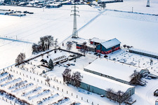 Aerial view of Schoßberghof in winter with snow in Minfeld in the state Rhineland-Palatinate, Germany