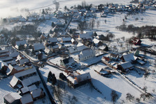 Aerial view of Wintry snowy Church building in the village of in Eberbach-Seltz in Grand Est, France