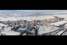 Aerial view of Panorama perspecitve of Wintry snowy Village - view on the edge of agricultural fields and farmland in Rohrbach in the state Rhineland-Palatinate, Germany