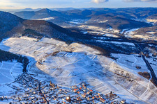 Wine-growing village under the Keschdebusch vineyard in winter with snow in Birkweiler in the state Rhineland-Palatinate, Germany out of the air