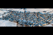 Village view in the evening light with snow in winter from the south in Minfeld in the state Rhineland-Palatinate, Germany