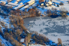 Frozen quarry lake in snow in winter in Neuburg am Rhein in the state Rhineland-Palatinate, Germany