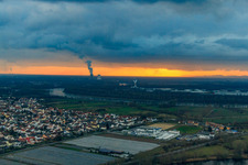 View of the town from the north with the Philippsburg nuclear power plant in the background at sunset in Altlußheim in the state Baden-Wuerttemberg, Germany