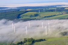 Rotors of wind farm Fürstenau protrude from low clouds in the district Fürstenau in Höxter in the state North Rhine-Westphalia, Germany