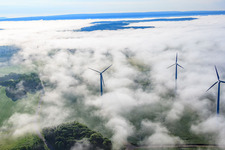 Aerial photograpy of Rotors of wind farm Fürstenau protrude from low clouds in the district Fürstenau in Höxter in the state North Rhine-Westphalia, Germany