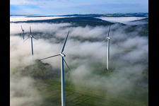 Rotors of wind farm Fürstenau protrude from low clouds in the district Fürstenau in Höxter in the state North Rhine-Westphalia, Germany from above